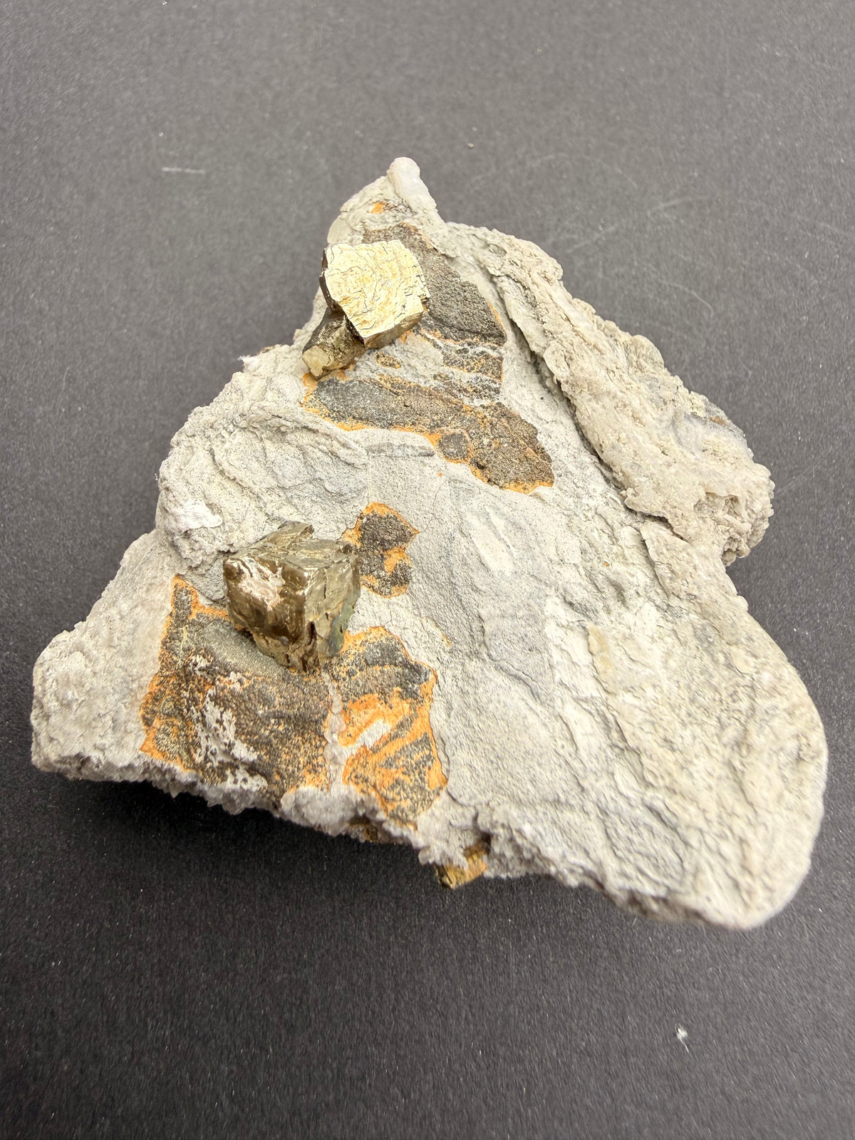 Close-up of cubic pyrite crystals growing on host rock