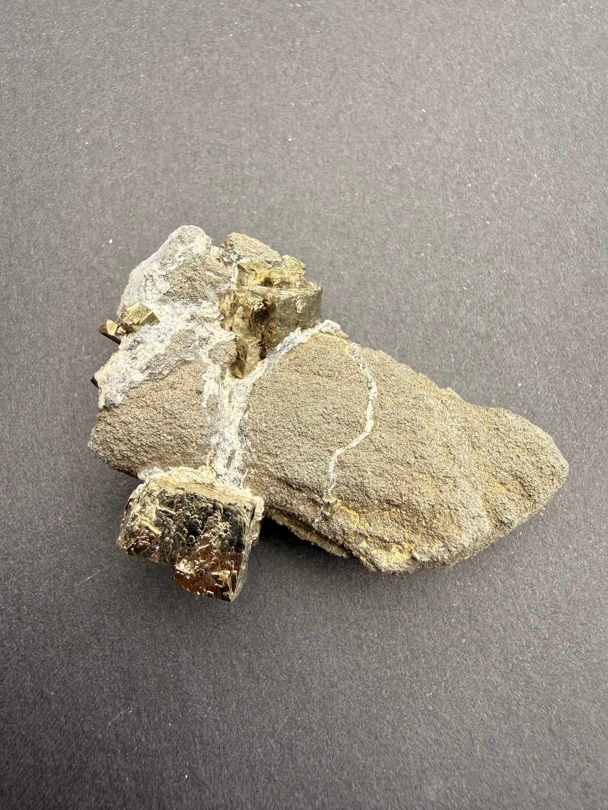Close-up of mirror-bright pyrite crystals on matrix rock